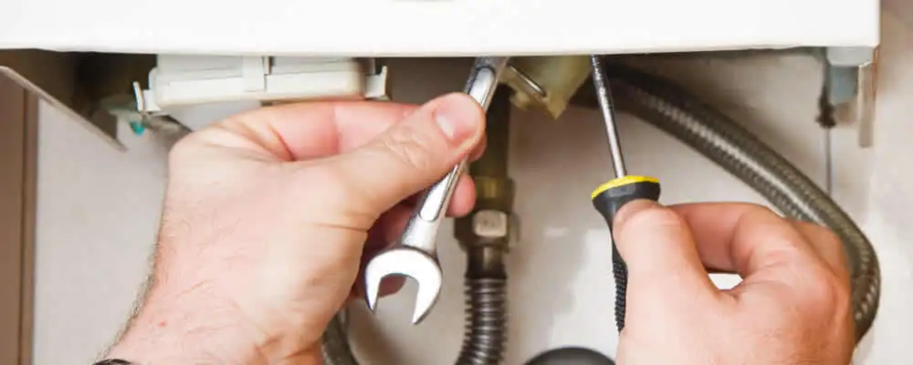 Boiler repair technician tightening pipe fittings and connections in Brandon, FL