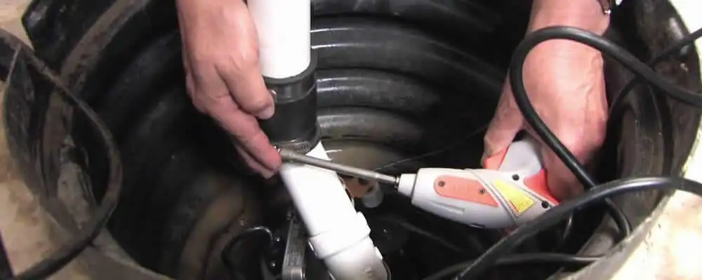 Sump pump installation technician connecting PVC discharge piping in Brandon, FL