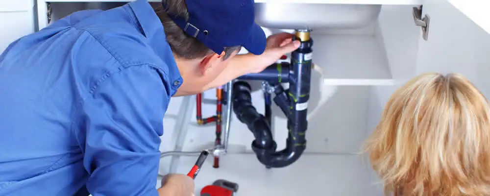 Plumber repairing under-sink drain pipes and fittings in Brandon, FL